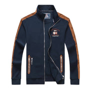 A navy blue zip-up jacket with brown shoulder panels and brown zipper pulls, featuring a high collar, white zipper lines, and a 'Socataj' embroidered patch on the left chest.
