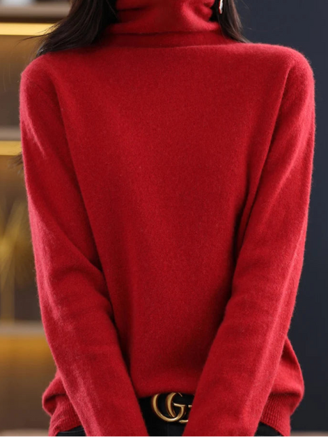 A close-up of a woman wearing a bright red, long-sleeve turtleneck sweater. The sweater is shown on a mannequin or model cropped from the nose down, 