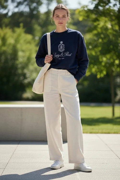 Person wearing a navy blue sweatshirt with a logo and text on a white background