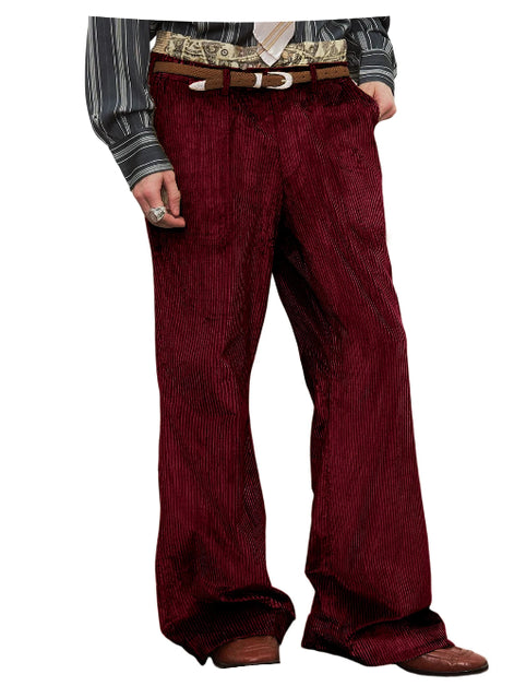 A pair of men's wide-leg corduroy trousers in a deep burgundy red, styled with a brown leather belt and a patterned shirt, shown on a white background.