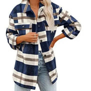 Woman wearing a navy and cream plaid shirt with jeans, against a white background.