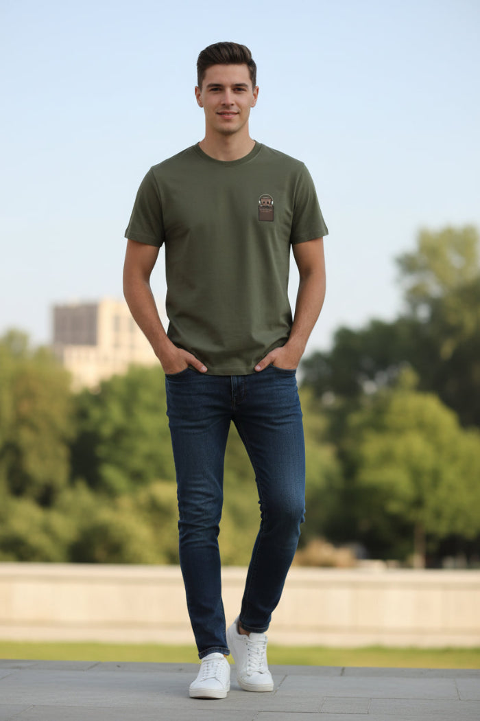 Green t-shirt with a brown patch on a hanger