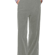 A person wearing high-waisted, wide-leg gray trousers with a lavender ruffled top and black shoes, shown from the waist down against a plain white background.
