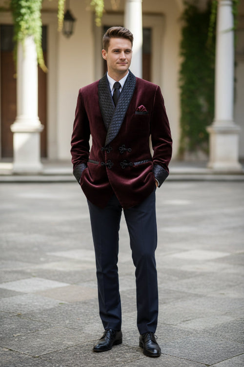 Man wearing a burgundy velvet suit with quilted lapels in a room with wooden paneling.