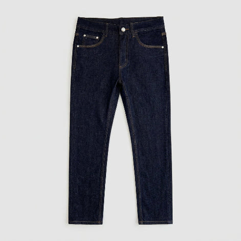 Dark indigo blue denim jeans laid flat on a white background, showing the front waistband, belt loops, button, pockets, and contrast stitching.