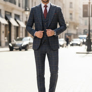Man wearing a checkered suit standing on a city street.