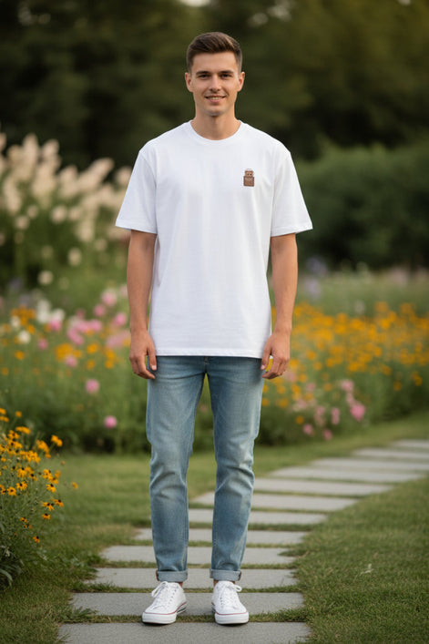 White t-shirt with a small brown and gold design on a hanger against a white background