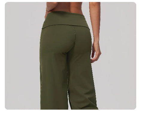 A close-up back view of a model wearing olive green wide-leg athletic pants against a light gray background.