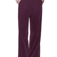 A person wearing high-waisted, wide-leg corduroy trousers in a deep plum purple, styled with a light lavender 