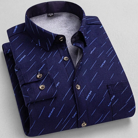 A folded men's button-up shirt in dark navy blue with a fine diagonal stripe pattern, featuring a visible gray fleece lining. The image includes a circular inset showing the plush fleece texture,