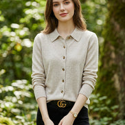 Woman wearing a light gray button-up shirt with a blurred background