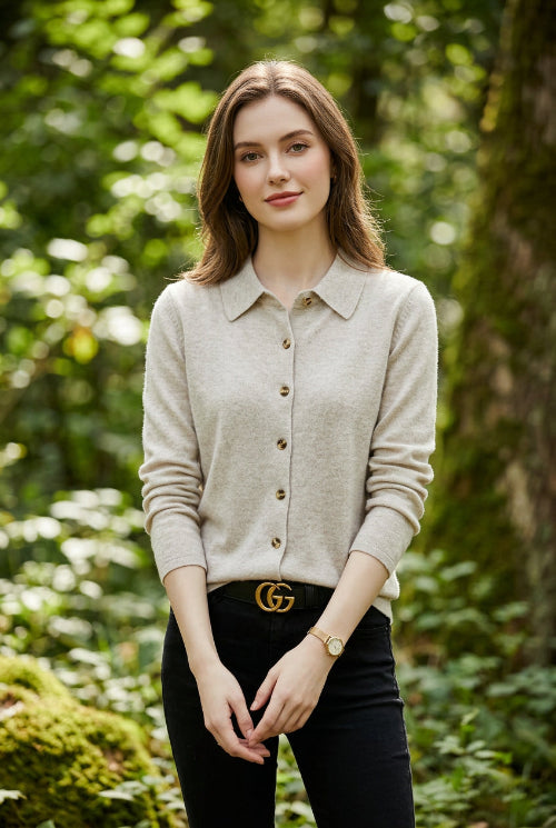 Woman wearing a light gray button-up shirt with a blurred background
