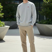 Gray sweatshirt with a small red logo on a white background