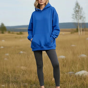 Person wearing a bright blue hoodie on a white background