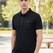 Navy blue polo shirt on a hanger with a hand touching it, brand logo visible