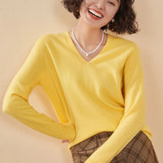 Woman wearing a yellow cashmere sweater with a beige background