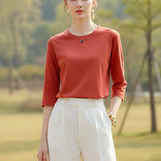 Person wearing a red long-sleeve top with a neutral background