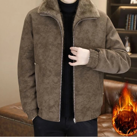 A man wearing a brown suede-like zip-up jacket with a thick faux-fur collar over a black turtleneck sweater. 