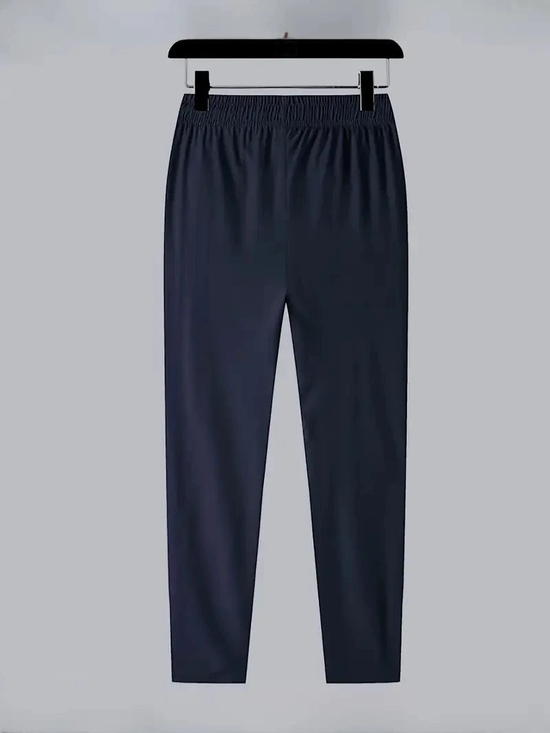 Navy blue pants on a hanger against a light gray background