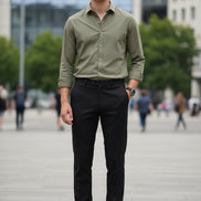 Person wearing black pants with one leg raised on a gray background