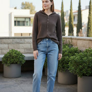 Person wearing a brown cardigan in a clothing store setting