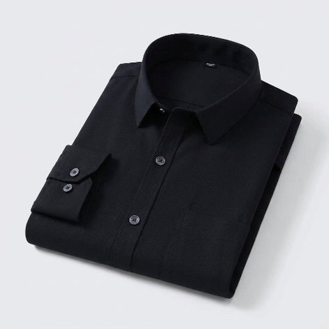 A folded black long-sleeve dress shirt with a pointed collar and silver buttons, shown on a white background 