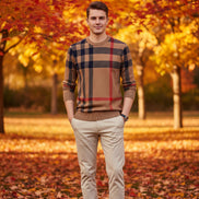 Plaid sweater with brown, red, and blue pattern worn by a person on a gray background