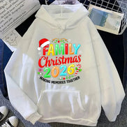 A white pullover hoodie laid flat with a colorful Christmas-themed graphic reading 'FAMILY Christmas 2026' and 'MAKING MEMORIES TOGETHER,' plus a Santa hat and candy cane motifs. 