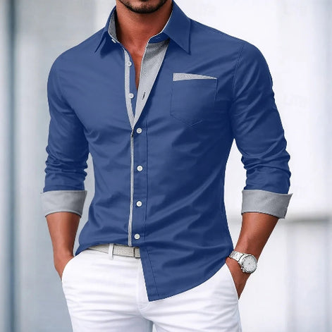 Man wearing a blue dress shirt with gray cuffs and collar, paired with white pants.