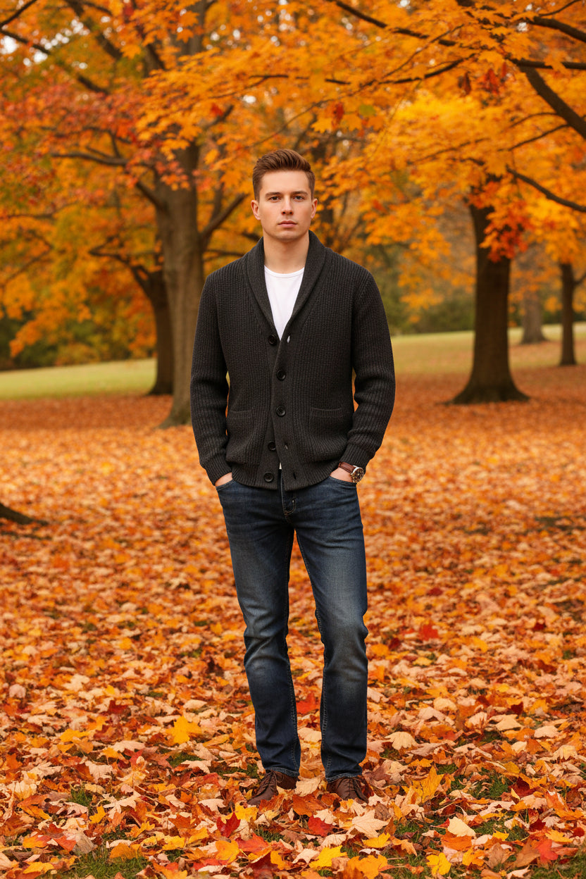 Person wearing a dark gray cardigan over a white shirt with a gray background