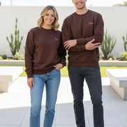 A brown crewneck sweatshirt with a small pink embroidered 'Dime' logo on the left chest, displayed on a clean white background.
