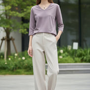 Person wearing a light purple long-sleeve shirt with a neutral background