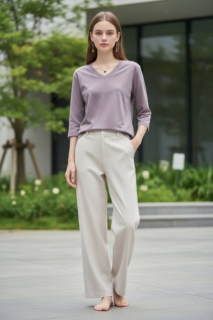Person wearing a light purple long-sleeve shirt with a neutral background