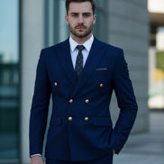 Man wearing a blue suit with gold buttons against a blurred background