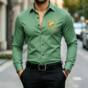 A man wearing a green long-sleeve button-up shirt with a gold embroidered horse logo and the text 'Success iat first try on the left chest, 