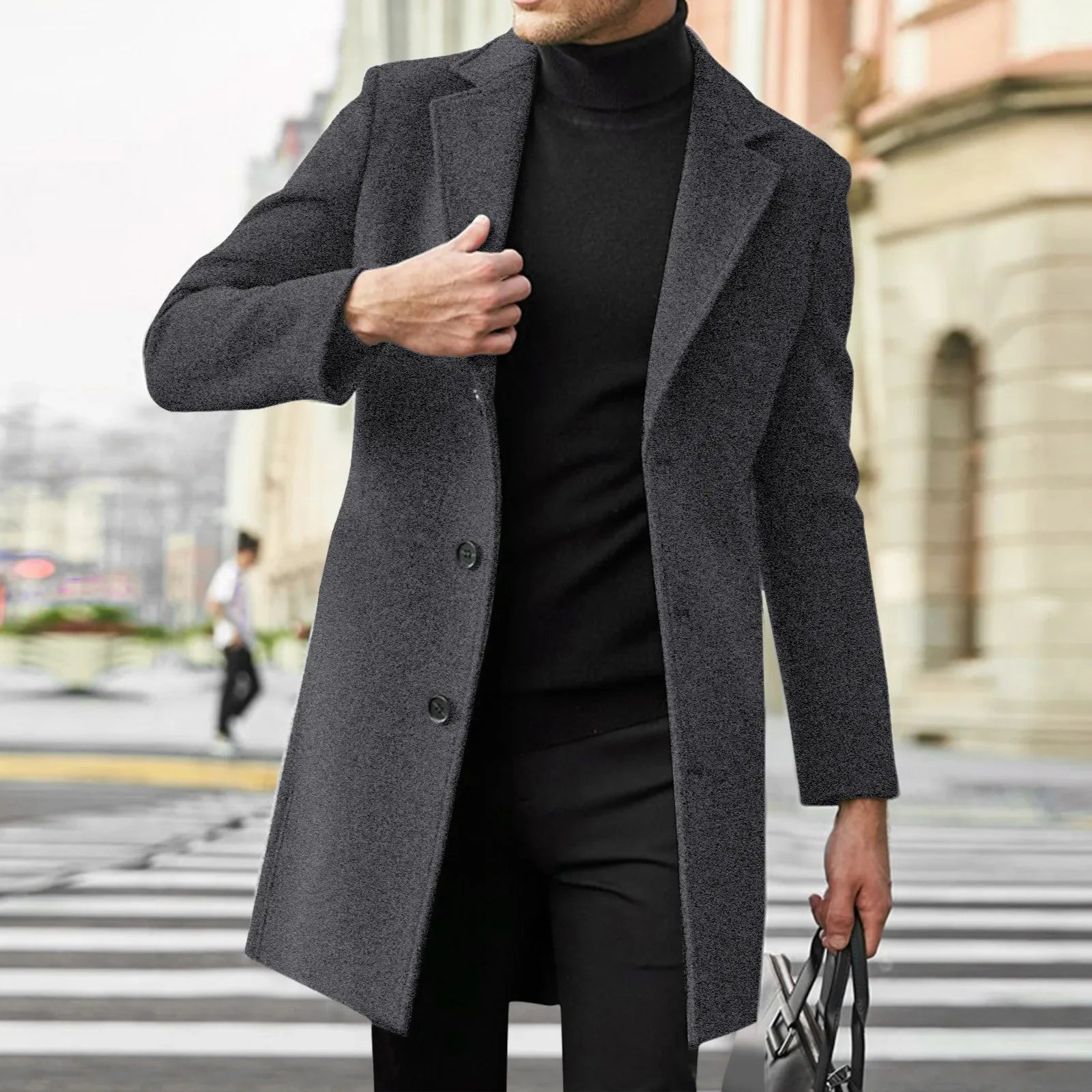 Person wearing a gray coat over a black outfit on a city street.