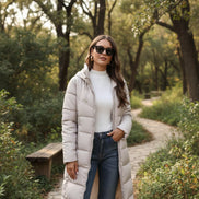 Woman wearing a long beige puffer coat in an urban setting