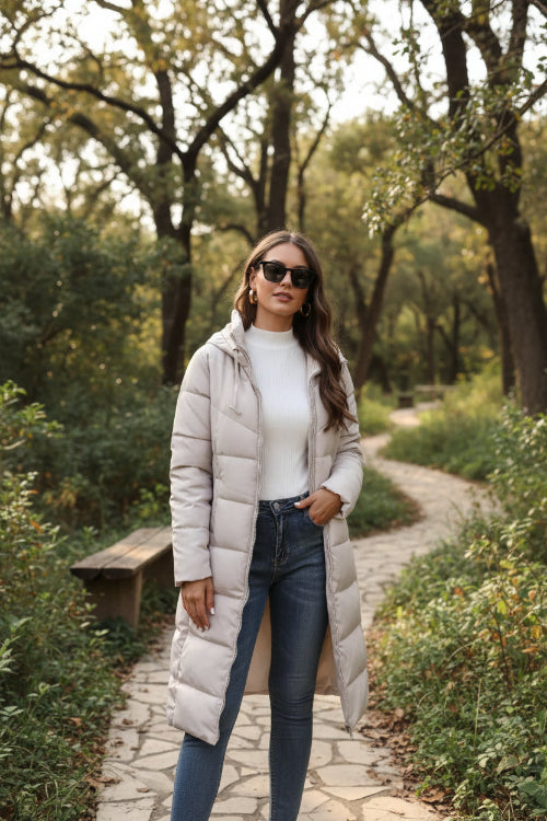 Woman wearing a long beige puffer coat in an urban setting