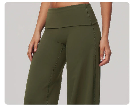 Olive green high-waisted wide-leg yoga pants shown on a model, featuring a double waistband and side pockets, against a solid gray background.