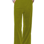 A person wearing olive green wide-leg corduroy trousers, styled with a light lavender ruffled shirt and black leather shoes