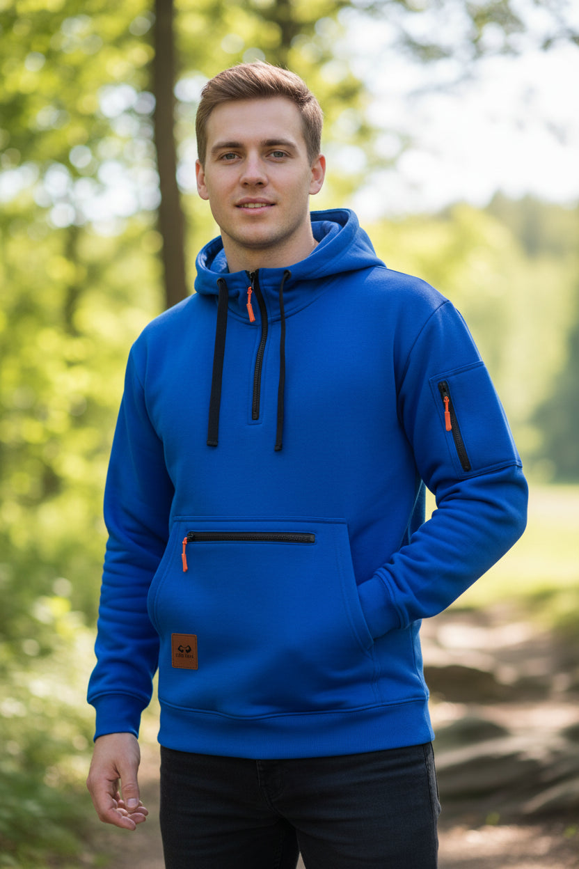 A bright blue pullover hoodie with a half-zip neckline, black drawstrings, a black horizontal zippered front pocket, a vertical zip pocket on the sleeve, and a small brown brand patch near the lower left front.