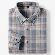 A folded long-sleeve plaid button-down shirt in gray with beige and white stripes, shown on a clean white background.