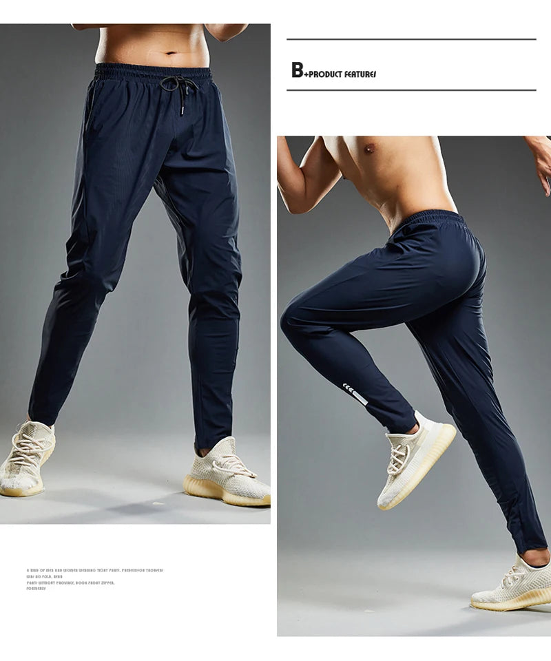 Navy blue jogger pants worn by a person on a gray background