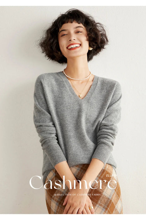 Woman wearing a gray cashmere sweater with 'Cashmere' branding.