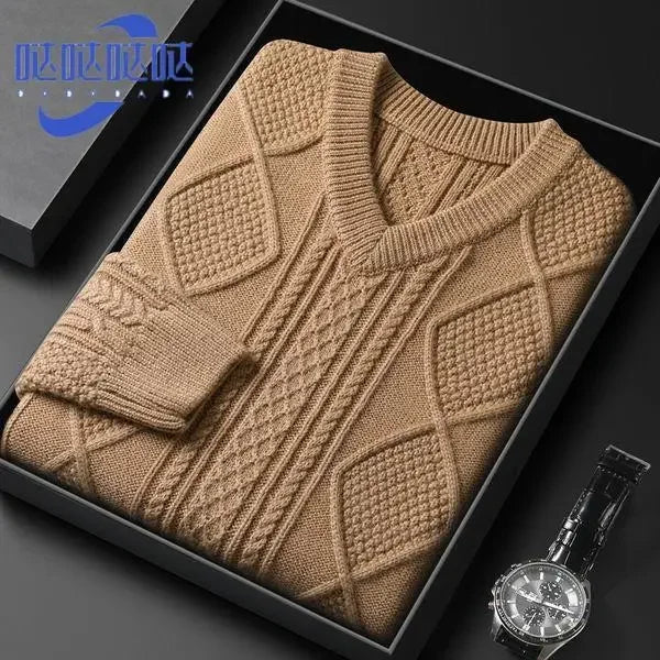 Brown knitted sweater in a black box with a watch on a dark surface