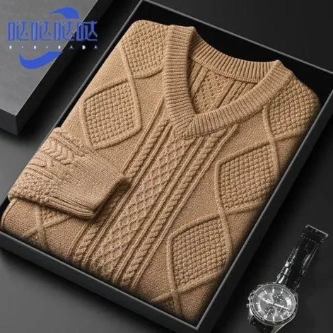 Brown knitted sweater in a black box with a watch on a dark surface