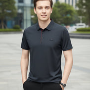 Dark gray polo shirt with a small logo on a gray background