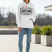 A white pullover hoodie laid flat with a front kangaroo pocket and a large holiday graphic reading 'family CHRISTMAS 2026' 