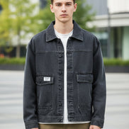 Person wearing a black denim jacket on a white background