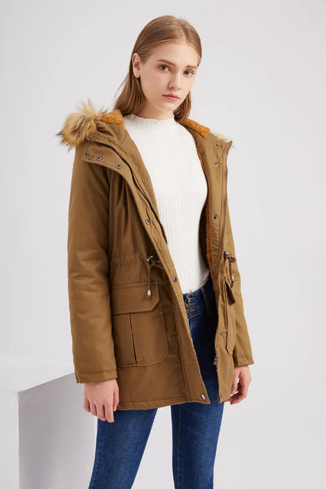 Woman wearing a brown parka coat with fur hood on a white background